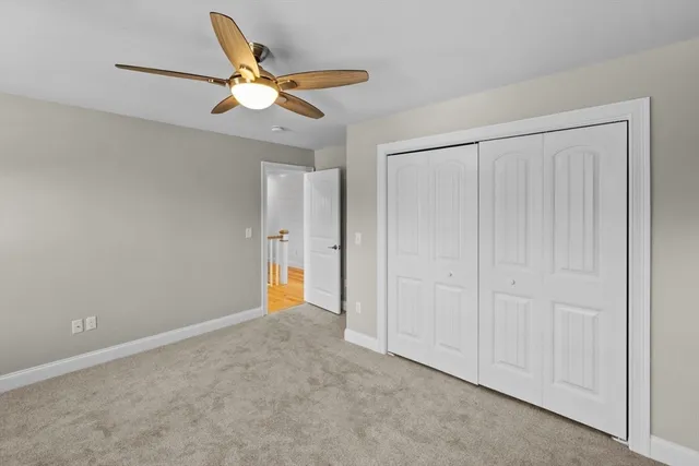 an empty room with windows and fan chandelier fan