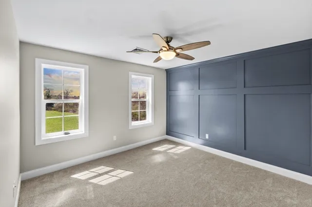 an empty room with closet and fan