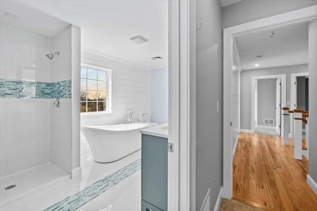 a spacious bathroom with a double vanity sink a mirror and a bathtub