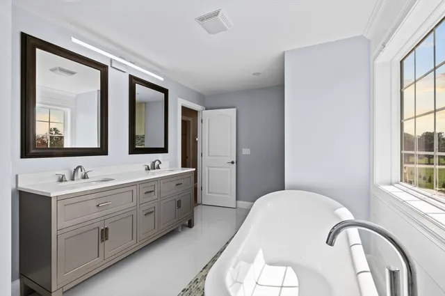 an empty room with windows and ceiling fan