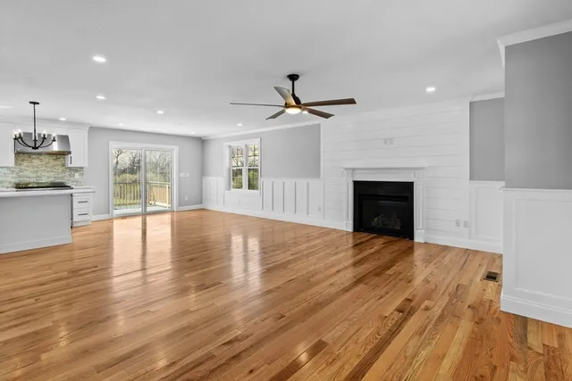 a view of empty room with wooden floor and fireplace