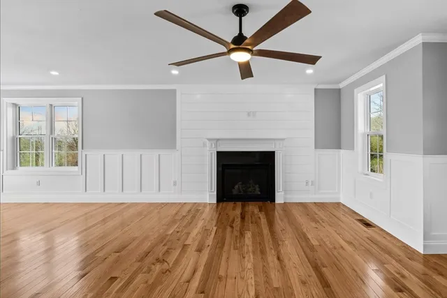 a view of empty room with wooden floor and fan