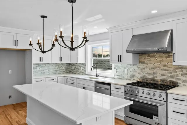 a kitchen with stainless steel appliances granite countertop a stove a sink and a microwave