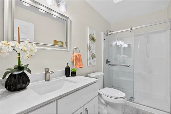 a bathroom with a sink a toilet and shower