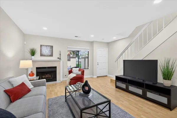a living room with furniture a flat screen tv and a fireplace