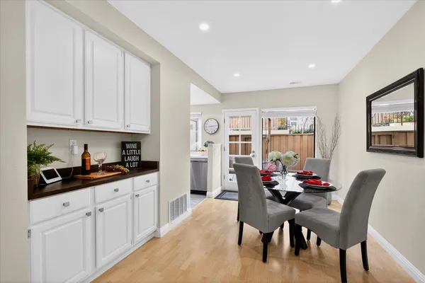 a kitchen with stainless steel appliances granite countertop a table and chairs in it