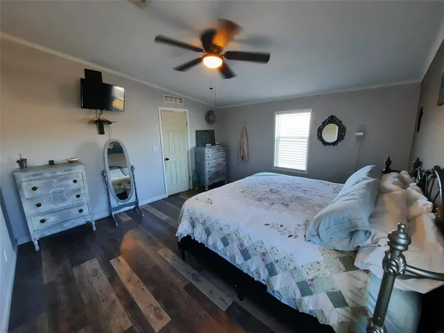 a spacious bedroom with a bed and a flat screen tv