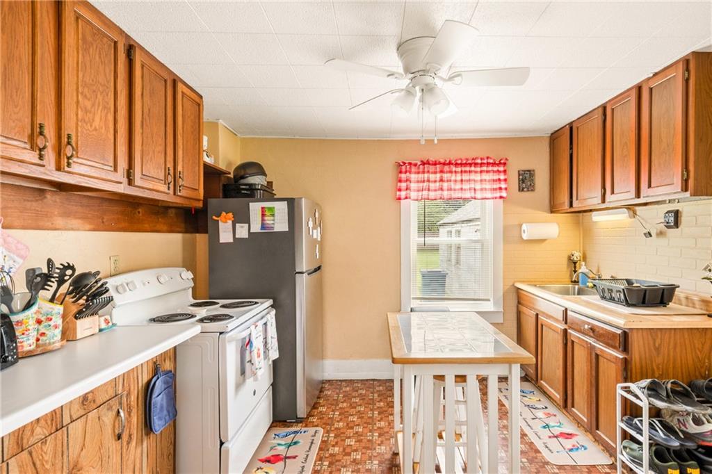 2030 Indian Head Road Indian Head, PA 15446 - Photo 10 of 26 a kitchen with stainless steel appliances a stove a sink a refrigerator cabinets and a window