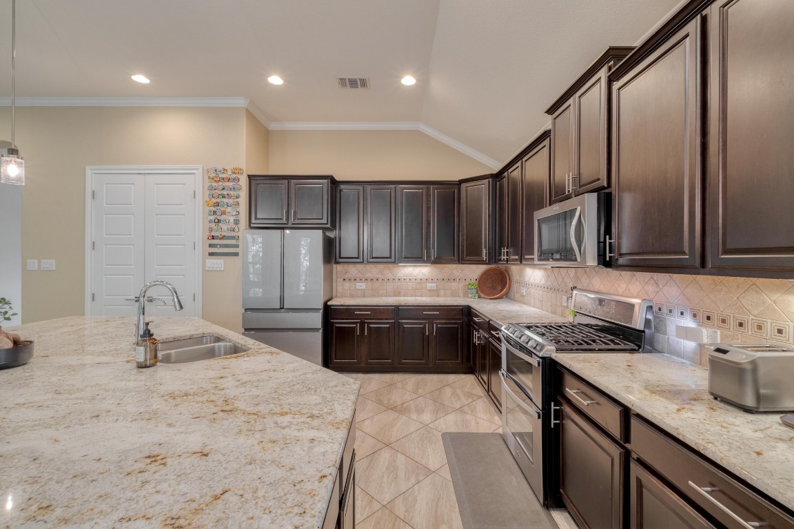 636 Trailside Bend Round Rock, TX 78665 - Photo 14 of 35 a kitchen with stainless steel appliances granite countertop a sink stove and cabinets