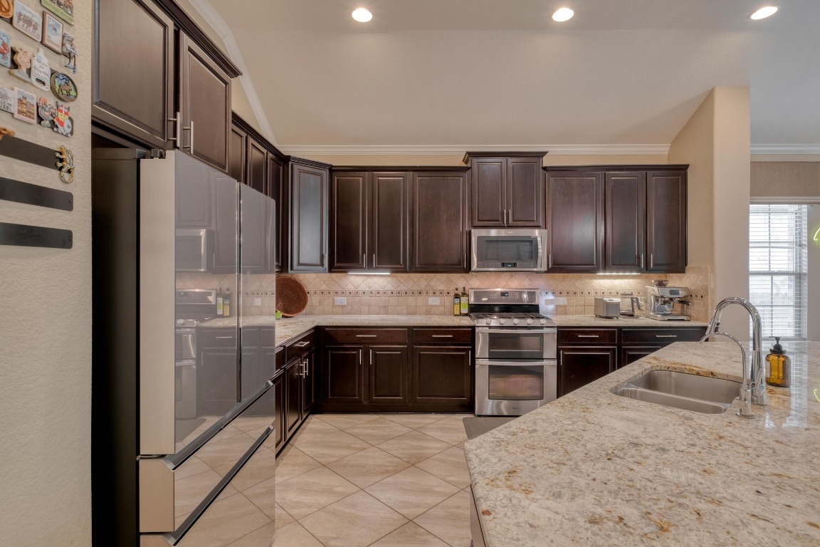 636 Trailside Bend Round Rock, TX 78665 - Photo 15 of 35 a kitchen with stainless steel appliances granite countertop a stove top oven a sink and dishwasher
