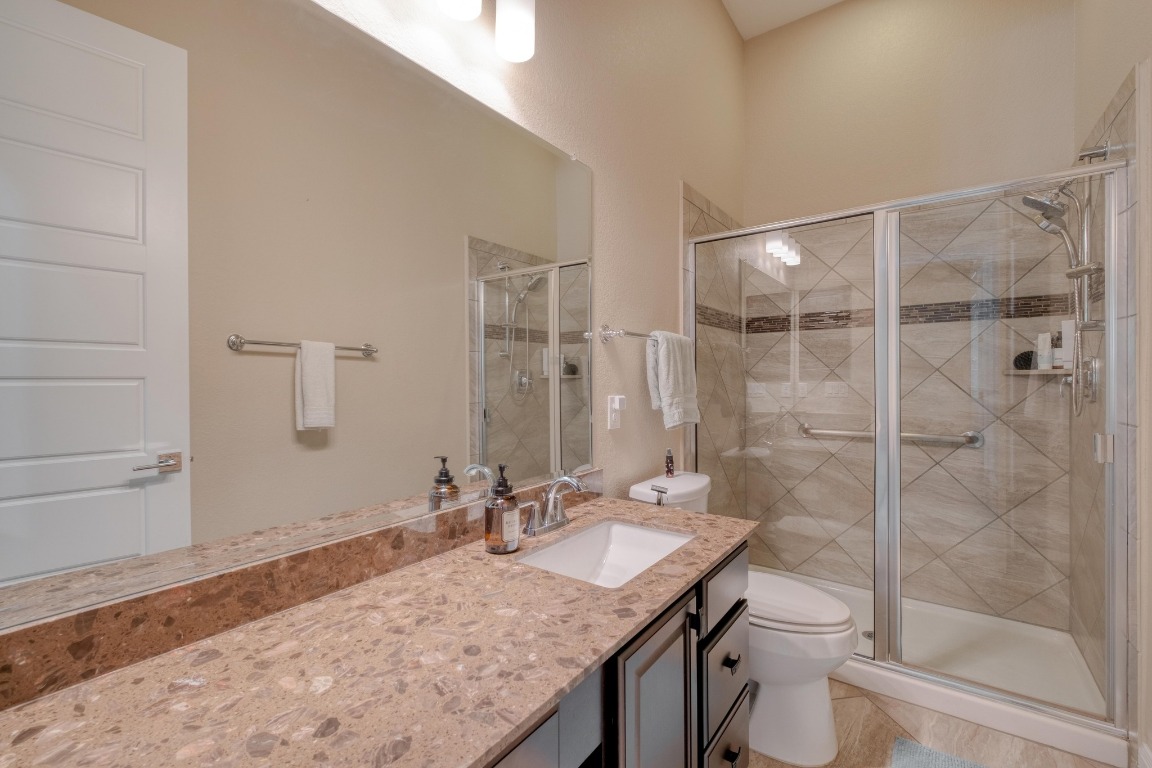 636 Trailside Bend Round Rock, TX 78665 - Photo 26 of 35 a bathroom with a granite countertop sink a toilet and shower