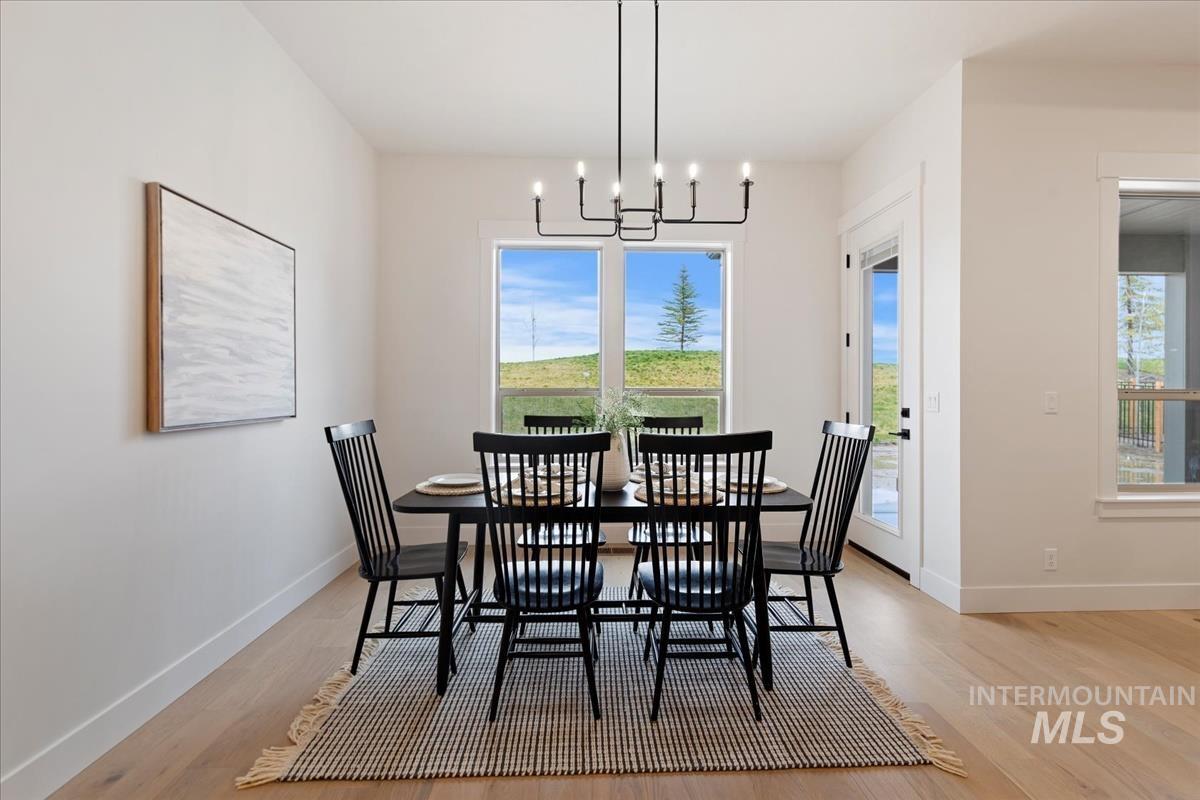 232 South Fusion Avenue Kuna, ID 83634 - Photo 17 of 30 Dining room with healthy amount of natural light, light wood-type flooring, and a chandelier