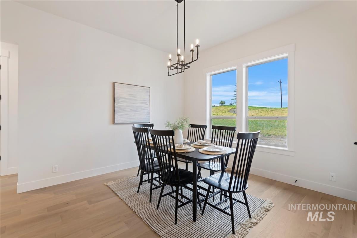 232 South Fusion Avenue Kuna, ID 83634 - Photo 18 of 30 Dining area featuring light wood-style flooring and a chandelier