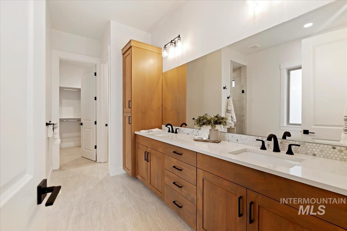 232 South Fusion Avenue Kuna, ID 83634 - Photo 24 of 30 Full bathroom featuring double vanity, a shower stall, and a walk in closet