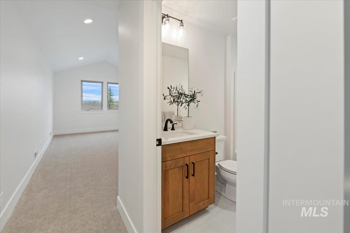 232 South Fusion Avenue Kuna, ID 83634 - Photo 28 of 30 Bathroom with vanity, light carpet, lofted ceiling, and recessed lighting