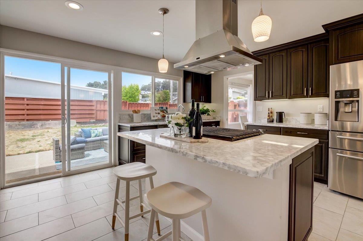 1209 Ridgewood Drive Millbrae, CA 94030 - Photo 15 of 59 a kitchen with stainless steel appliances granite countertop a stove a refrigerator a sink and a dining table with wooden floor