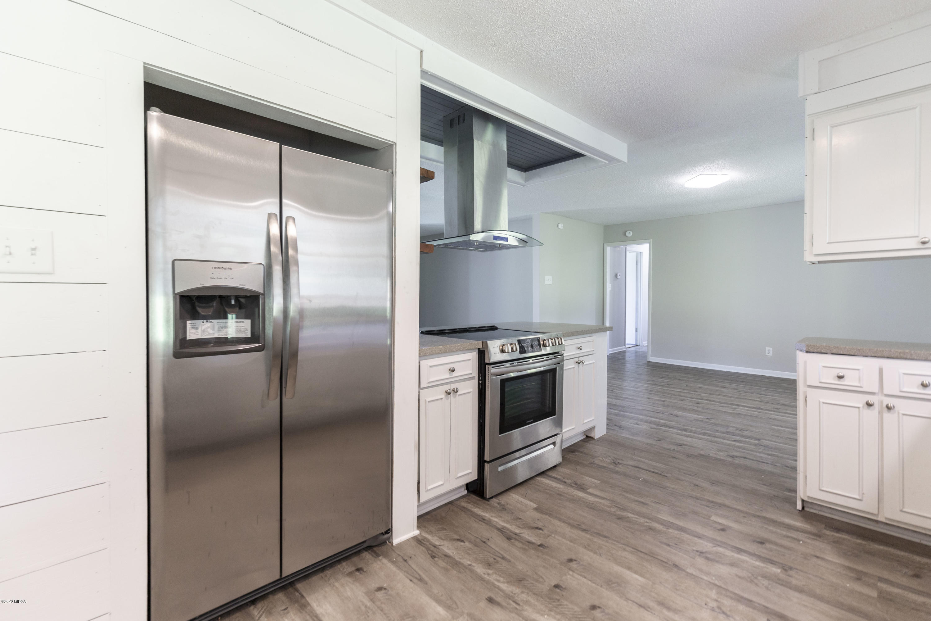 246 Allred Road Byron, GA 31008 - Photo 21 of 53 a kitchen with stainless steel appliances cabinets and wooden floor