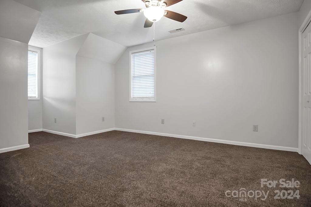 210 Harbor Point Drive Cherryville, NC 28021 - Photo 23 of 45 an empty room with a chandelier fan and windows