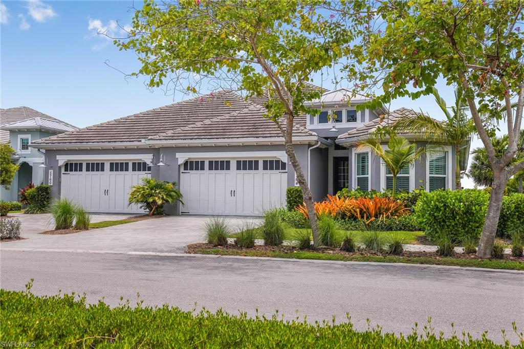 5764 Elbow Avenue Naples, FL 34113 - Photo 2 of 48 a front view of a house with a garden and plants