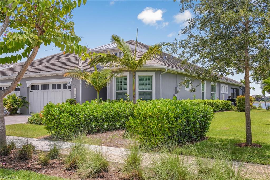 5764 Elbow Avenue Naples, FL 34113 - Photo 37 of 48 a front view of a house with garden