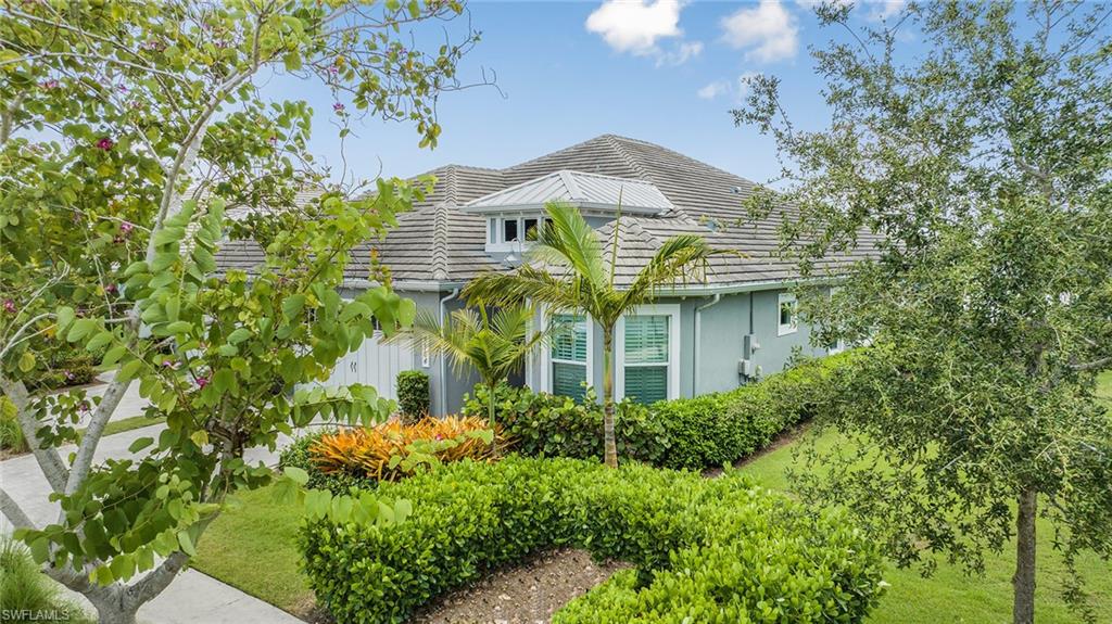 5764 Elbow Avenue Naples, FL 34113 - Photo 43 of 48 a view of a house with a flower garden