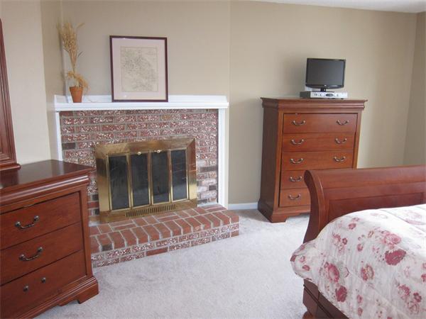 77 Mountain Gate Road, Unit 77 Ashland, MA 01721 - Photo 16 of 20 a bedroom with a bed and a fireplace