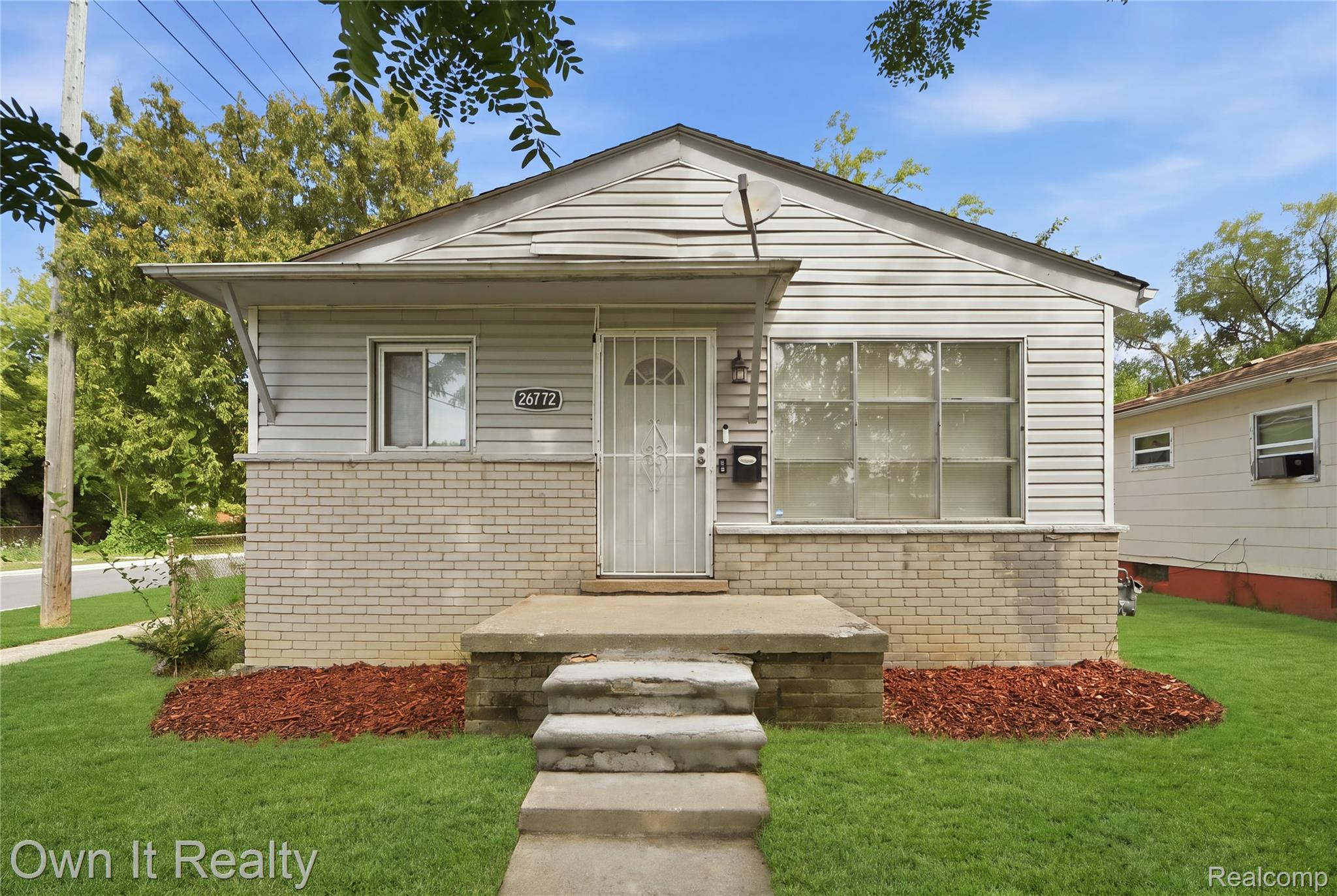 26772 Colgate Street Inkster, MI 48141 - Photo 1 of 25 Exterior featuring light-colored siding, a brick foundation, a concrete porch, and a well-maintained lawn