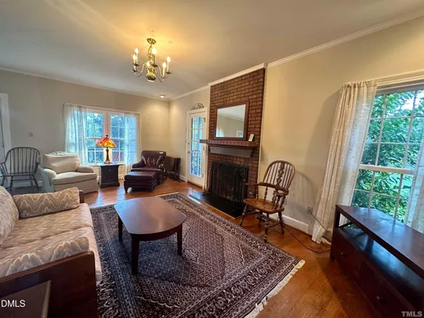a living room with furniture a large window and a fireplace