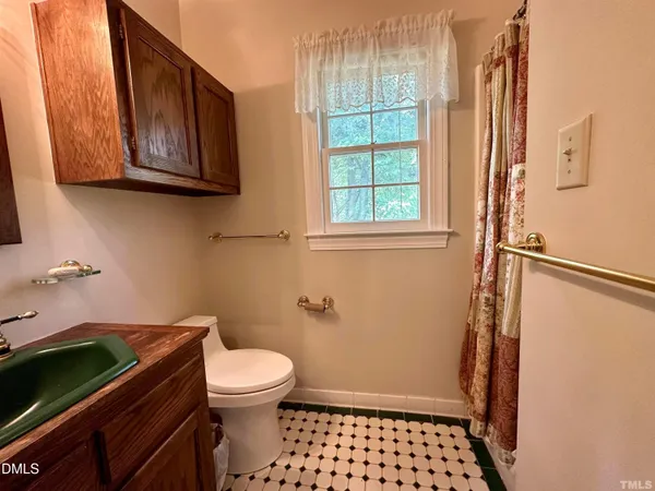 a bathroom with a toilet and a shower curtain