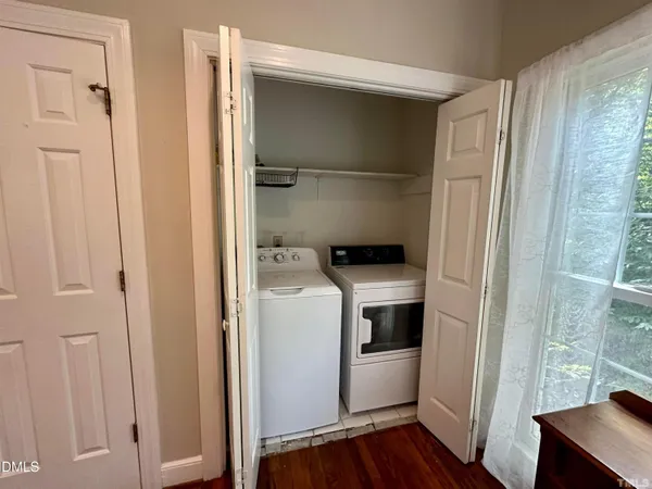 a utility room with wooden floor washer and dryer