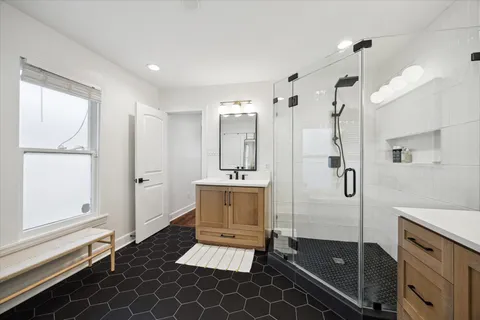 a bathroom with a double vanity sink a mirror and a shower