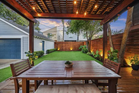 a view of table and chairs with wooden floor and fence