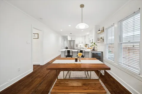 a view of a dining room and livingroom with furniture wooden floor a rug and a chandelier