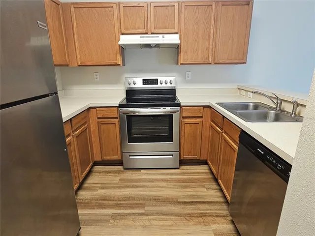 a kitchen with granite countertop a stove top oven and cabinets