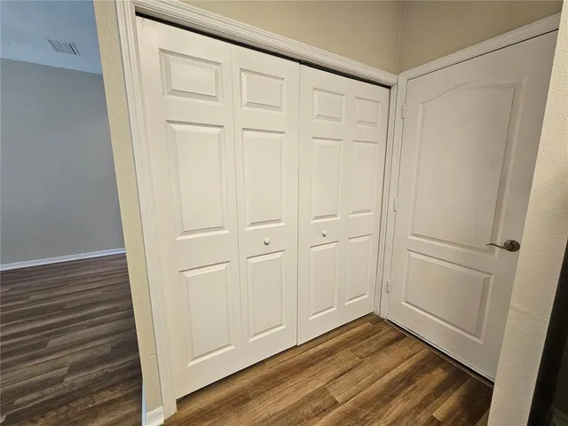 a view of empty room with wooden floor