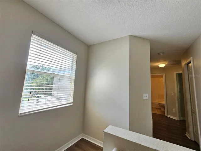 a view of hallway with window and bathroom