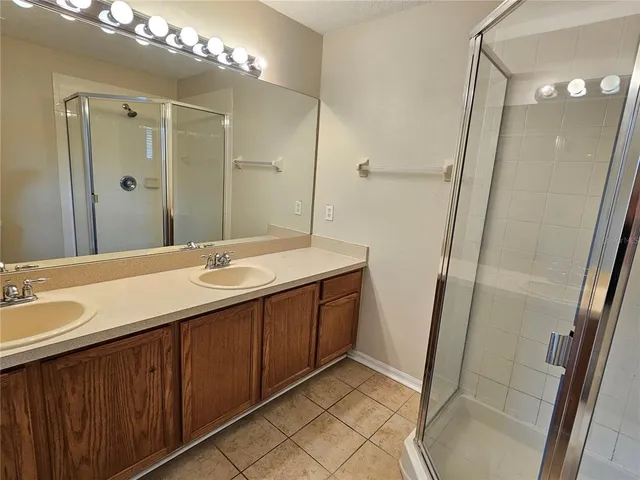 a bathroom with a double vanity sink mirror and shower