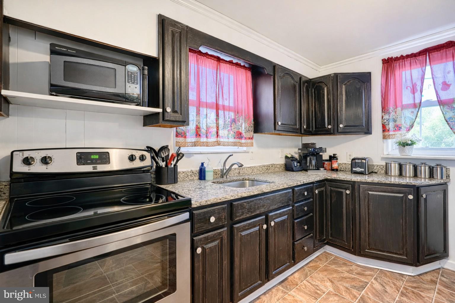 a kitchen with stainless steel appliances granite countertop a stove microwave and sink
