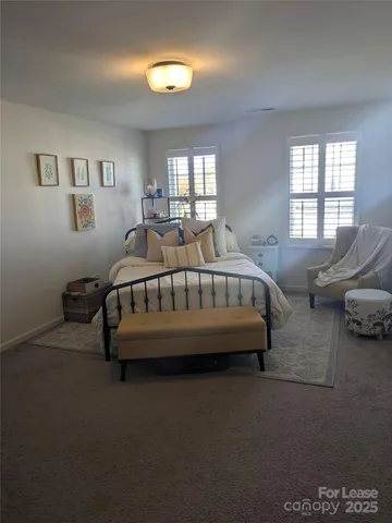 a bed sitting in a bedroom next to a window