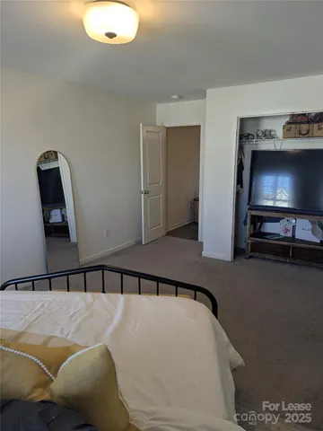 a bedroom with a bed and a television
