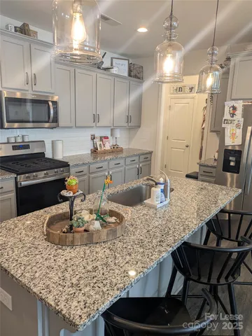a kitchen with granite countertop a table chairs stove and cabinets