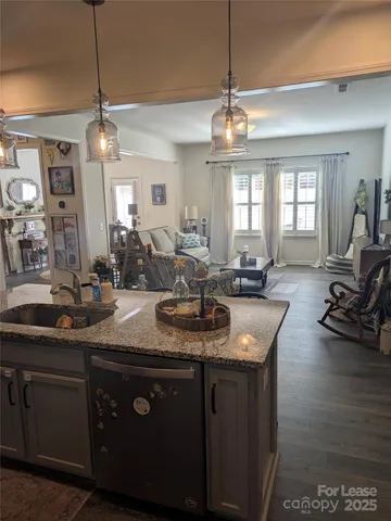 a kitchen with stainless steel appliances granite countertop a sink a stove and a wooden floors