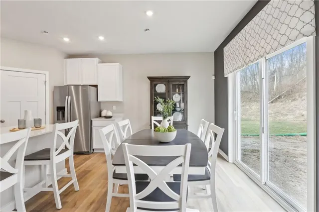 a kitchen with stainless steel appliances kitchen island granite countertop a refrigerator and a dining table