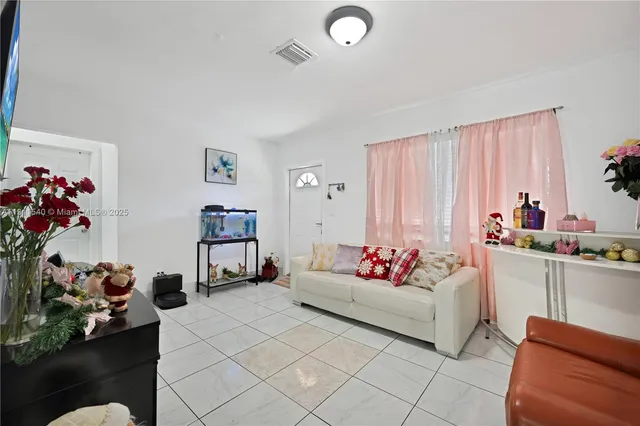 a living room with furniture and a potted plant