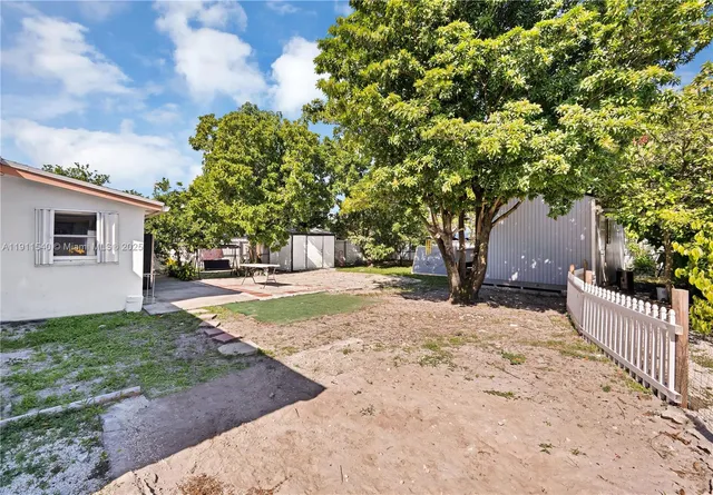a view of a yard with plants and trees