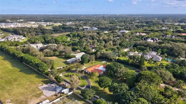 an aerial view of residential houses with outdoor space and trees