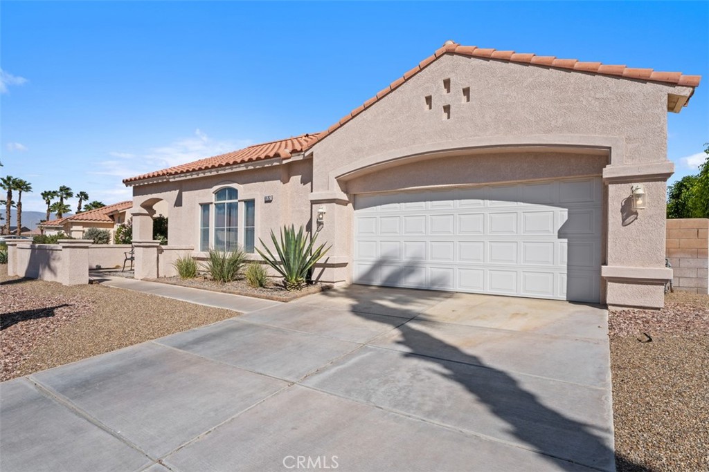 68262 Pasada Road Cathedral City, CA 92234 - Photo 2 of 27 a front view of a house with a yard and garage