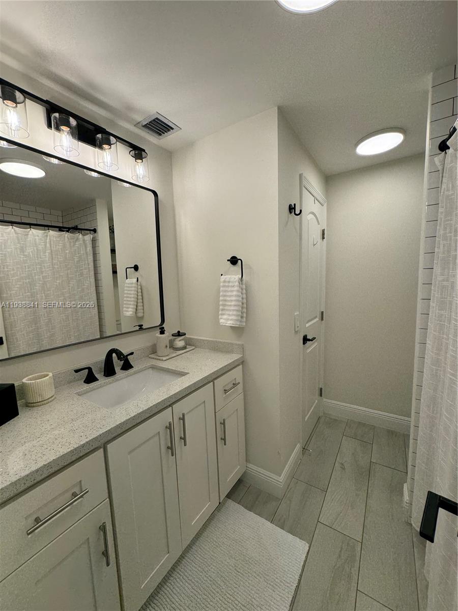10069 Southwest 77th Court Miami, FL 33156 - Photo 5 of 16 a bathroom with a double vanity sink mirror and shower