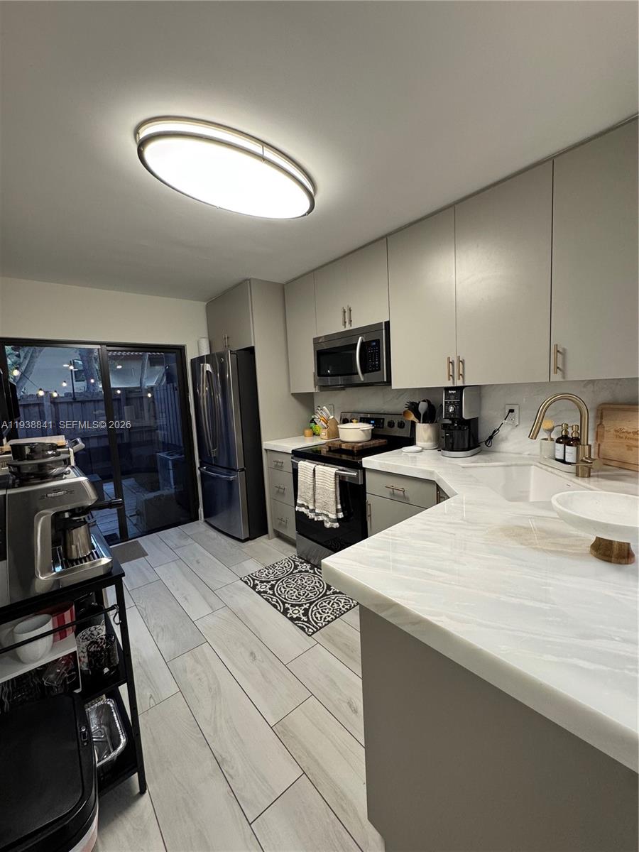 10069 Southwest 77th Court Miami, FL 33156 - Photo 7 of 16 a kitchen with a sink stainless steel appliances and cabinets