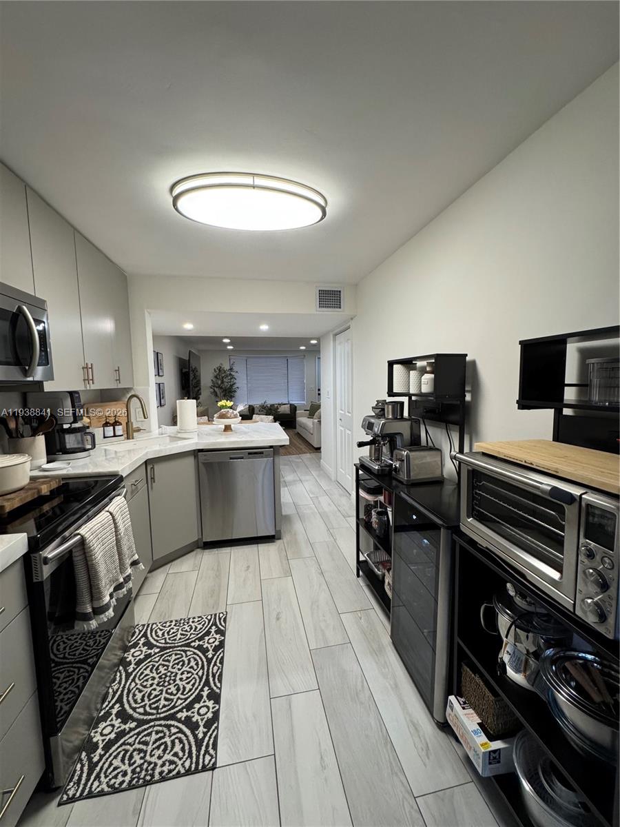 10069 Southwest 77th Court Miami, FL 33156 - Photo 8 of 16 a kitchen with stainless steel appliances a stove a sink and a refrigerator